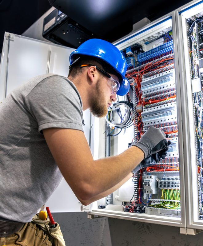 Male electrician in uniform working in a switchboard. Electricity. High quality photo. Male electrician in hard hat. A male electrician solves a problem with electricity. SSUCv3H4sIAAAAAAAAA41PQY6DMAz8i88gBQLdwleqHkJiqFVKqsRstUL5+zqUaq+b04wnnhlvQA56aMeTG61RZd2or7KqRlUOtq7LRne6bXWHZnRQgDOM0Fdad0qflT7VVXNW8goYTCQL/QY0z2vkYJj8Ar0oAReHYYfoiH0gMwtLBUQ2vEaMsibMivck6s4/fpctz6WghMd1yCAV/5xdCzATLvYn+6dcZEazx11Eur8Yw+PI9nzLFTN8BrK0TEcnOcU/3njxnHf3BPb2Tu5Yfp9xI5mGnAXrc/bGoTvkdXgQ84cG/CZ8/f1OKf0C+YvR/oQBAAA=